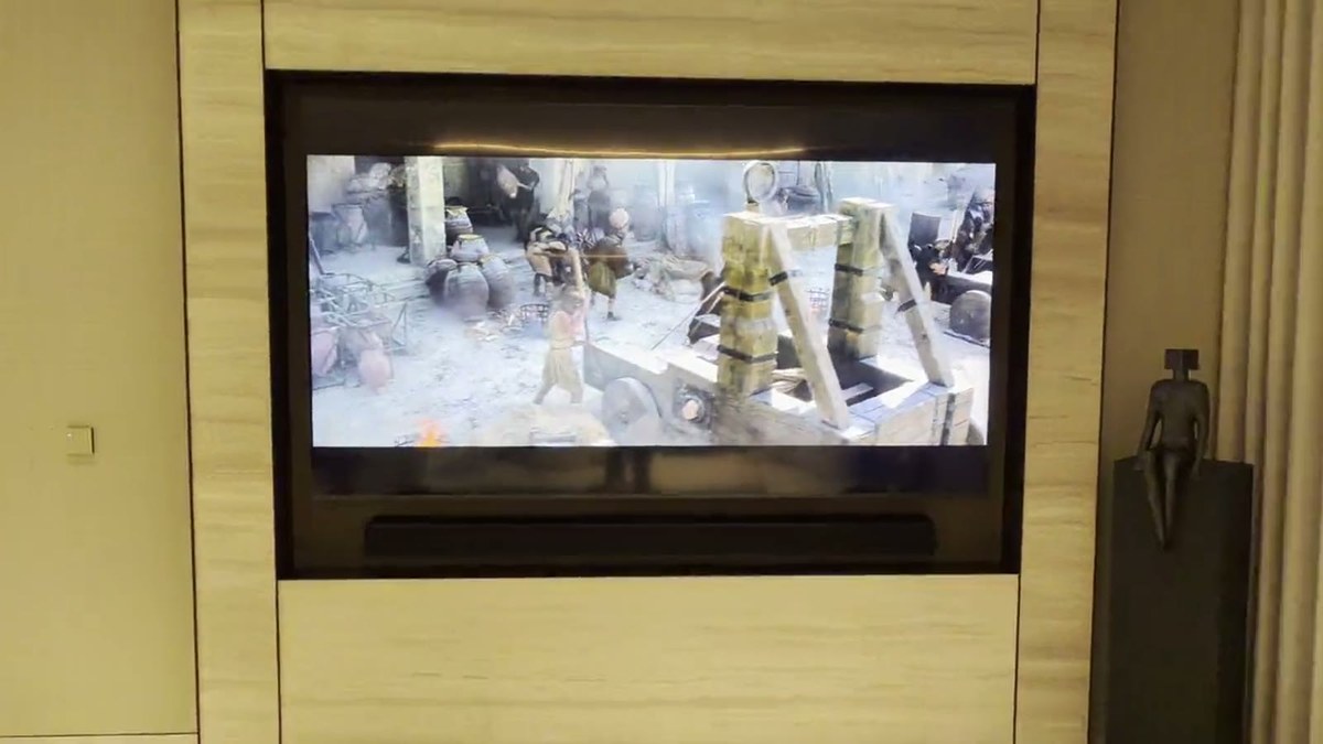 The custom XSCACE LCR soundbar mounted flush in the stone recess directly beneath the recessed television
