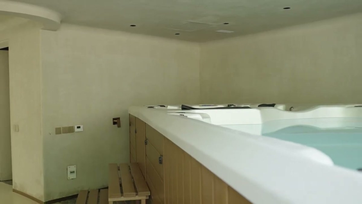 The wellness suite with a spa pool set into timber decking and a flush in-ceiling speaker above