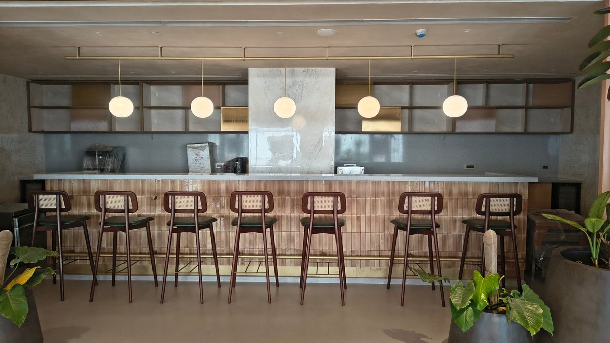 The clubhouse bar with pendant lighting, a tiled counter front and bar stools