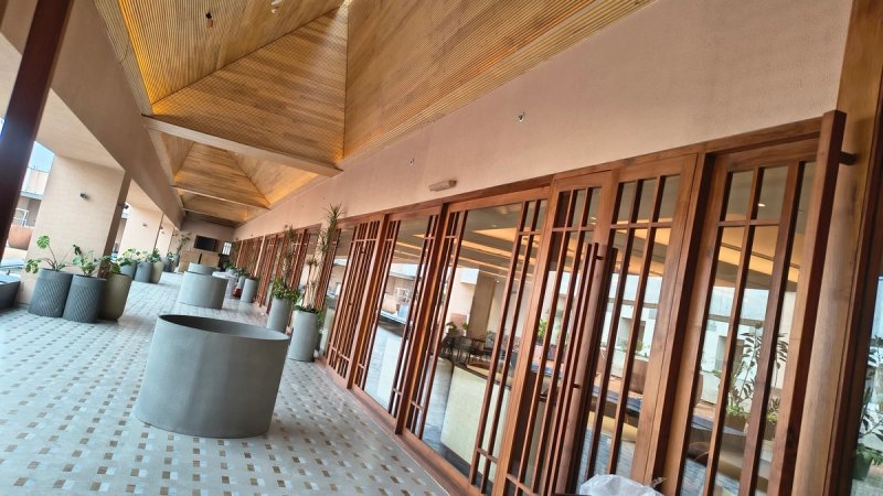 The covered terrace of a clubhouse restaurant with a timber soffit, folding teak doors and a Cedar slim array mounted above the door line