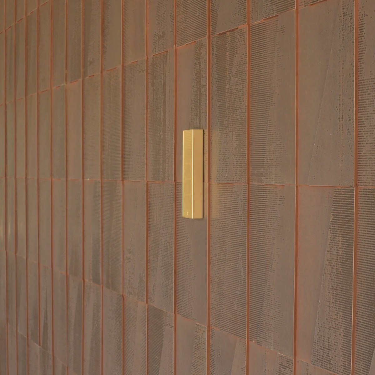 XSCACE Cane speaker mounted on a weathered Corten steel exterior facade panel