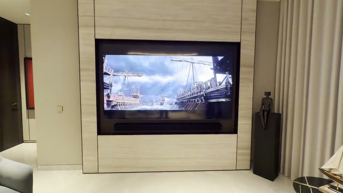The custom XSCACE LCR soundbar mounted flush in the stone recess directly beneath the recessed television