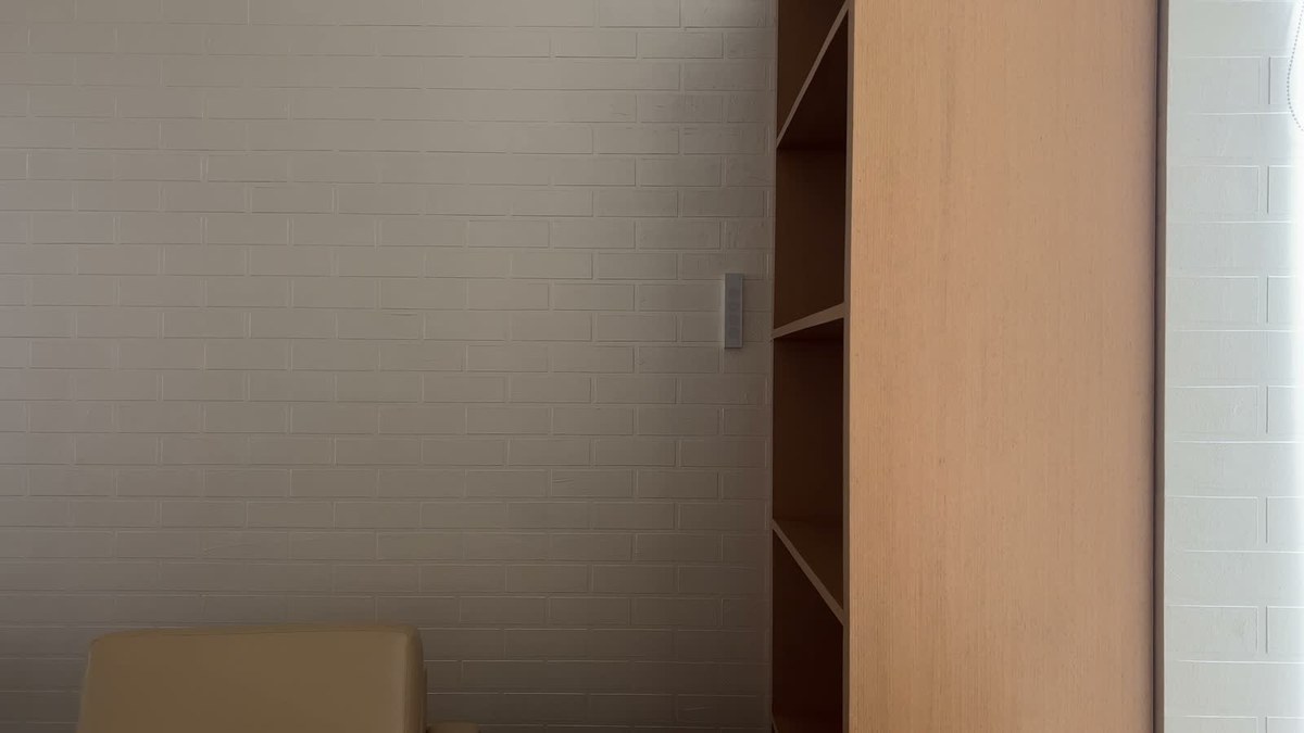 A white XSCACE Cane slim array on a painted brick wall beside oak shelving in a clubhouse games room