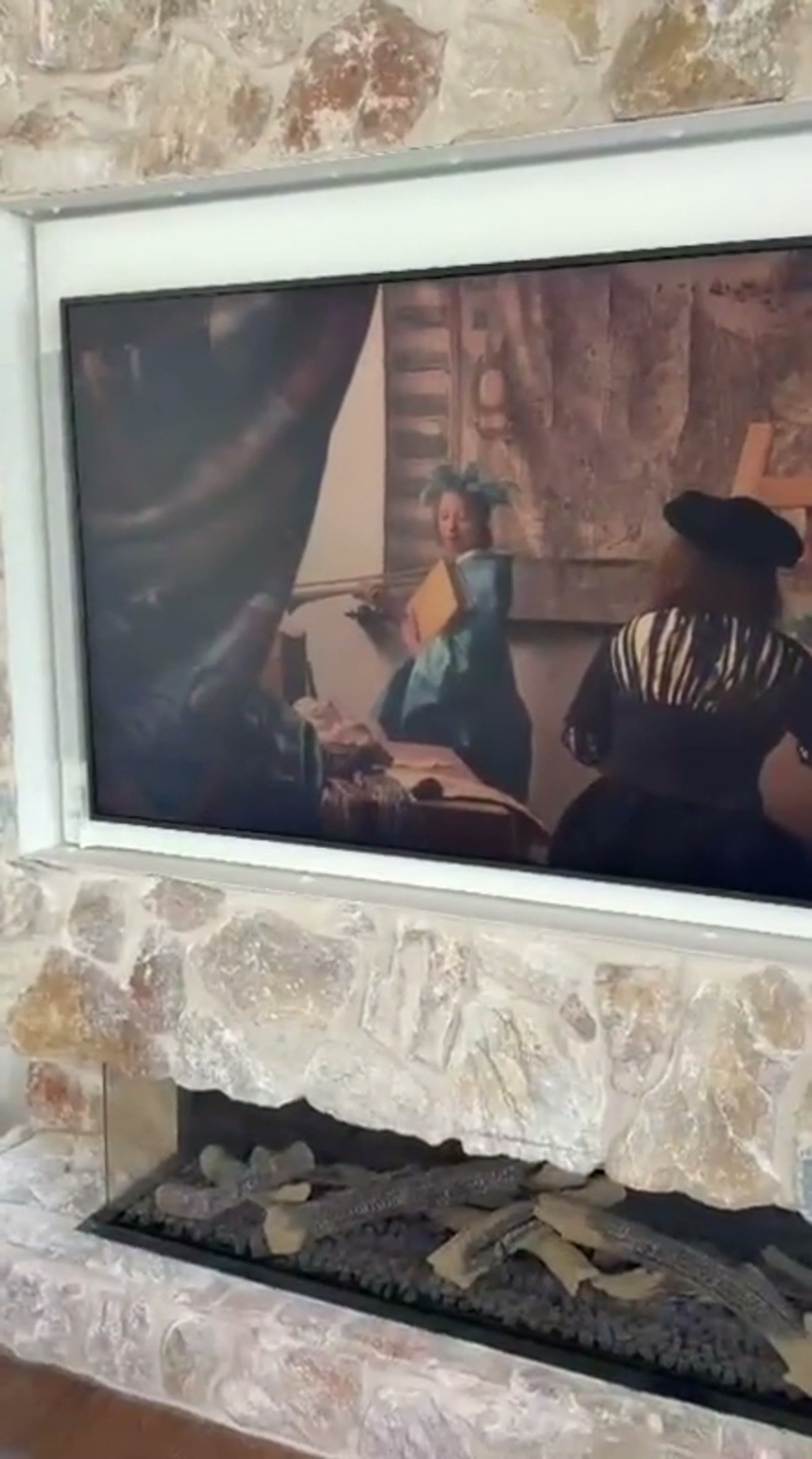 The QuadCane beside the framed painting on the stone wall