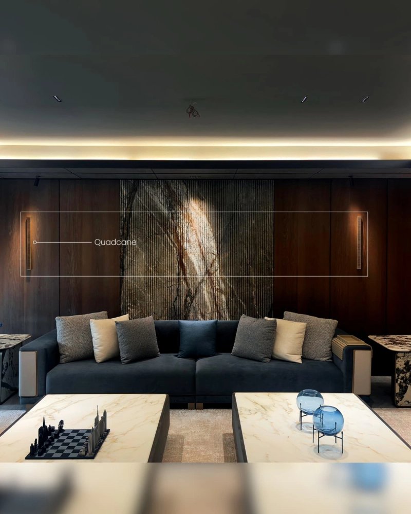 Dark wood and marble lounge with three XSCACE Quadcane speakers spread along the main wall