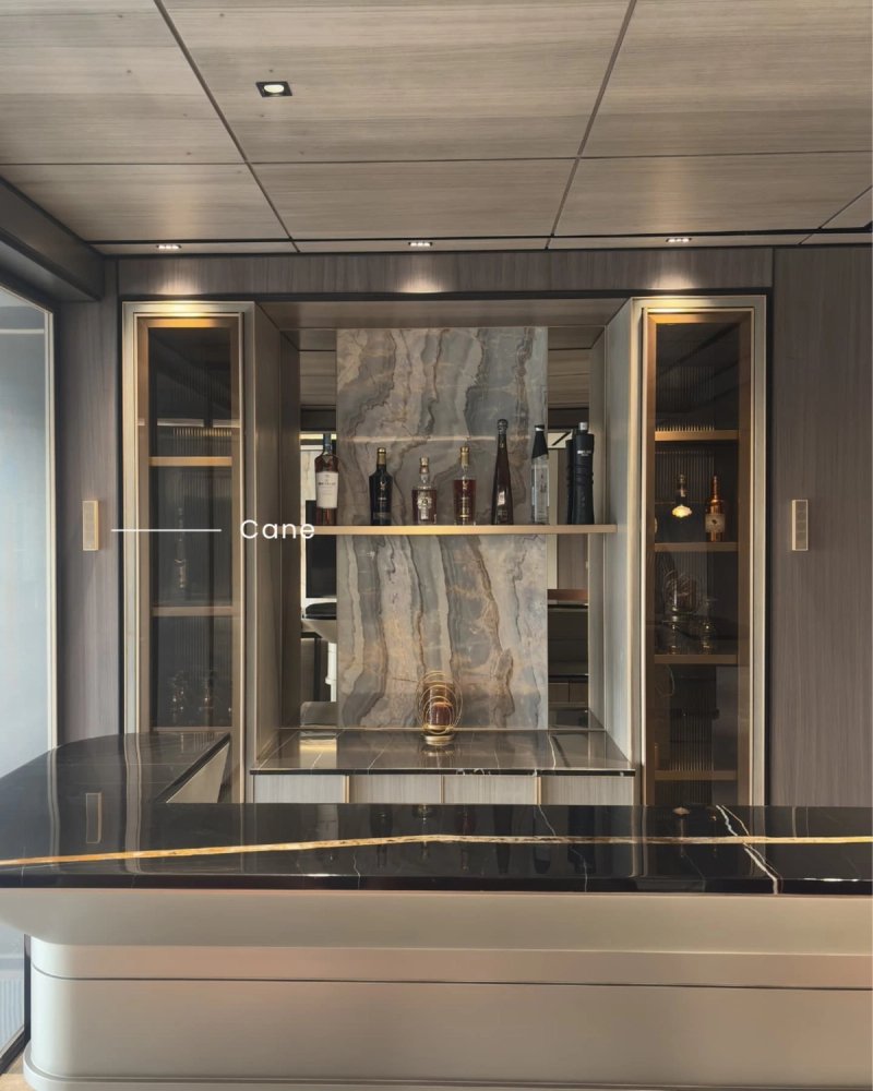 XSCACE Cane speaker mounted beside a marble-backed home bar shelf with bottles and ambient lighting