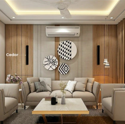 A modern contemporary living room setup highlighting two black XSCACE Cedar speakers vertically integrated into natural wood paneling behind a plush beige sofa set.
