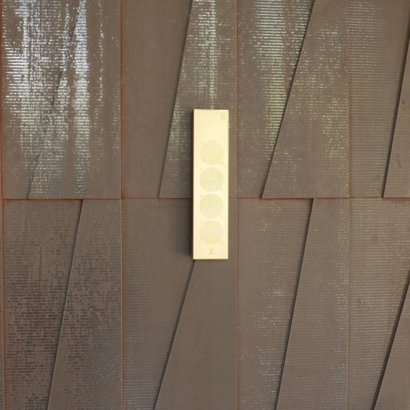 XSCACE Cane speaker mounted on a weathered Corten steel exterior facade panel