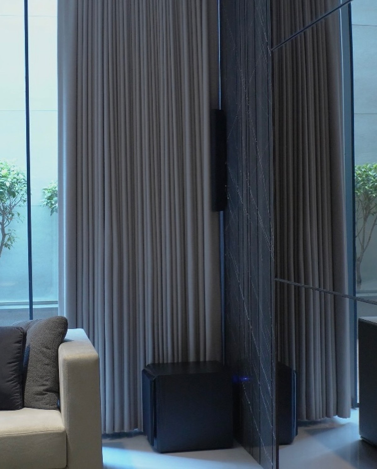 XSCACE Cedar speaker mounted on book-matched grey marble in a formal reception lounge