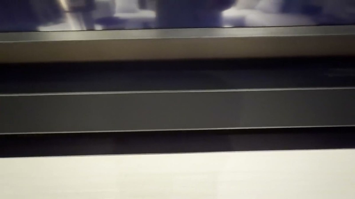 Close detail of the custom XSCACE soundbar showing the embossed XSCACE wordmark on its black anodised face