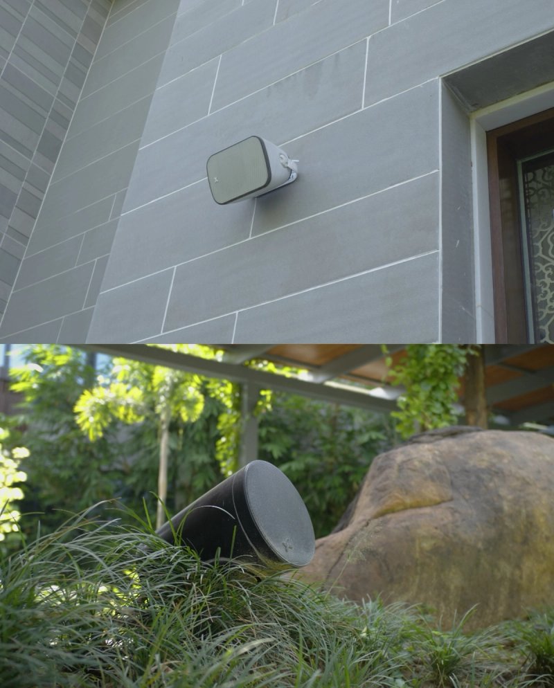 XSCACE Camphor outdoor speaker on a stone facade wall and Spirea landscape rock speaker among garden planting