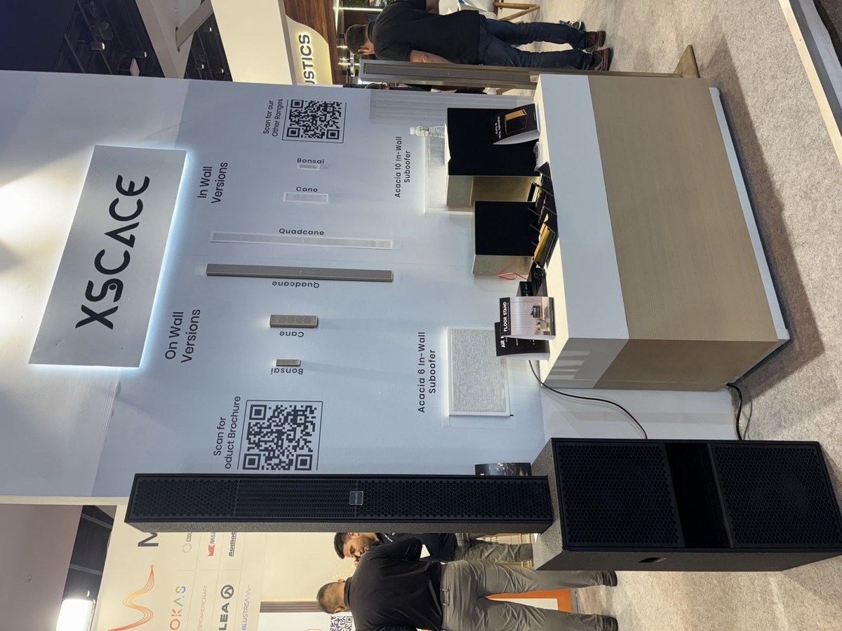 A display table at the XSCACE stand at Smart Expo 2026 showing the in-wall versions of the range laid out flat and labelled, with a QR code linking to the specifications