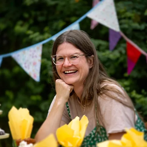 bilde av dame som smiler ved et pyntet bursdagsbord