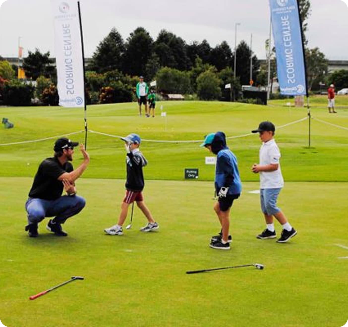 Man teaching children golf