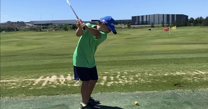 Kid swinging golf club