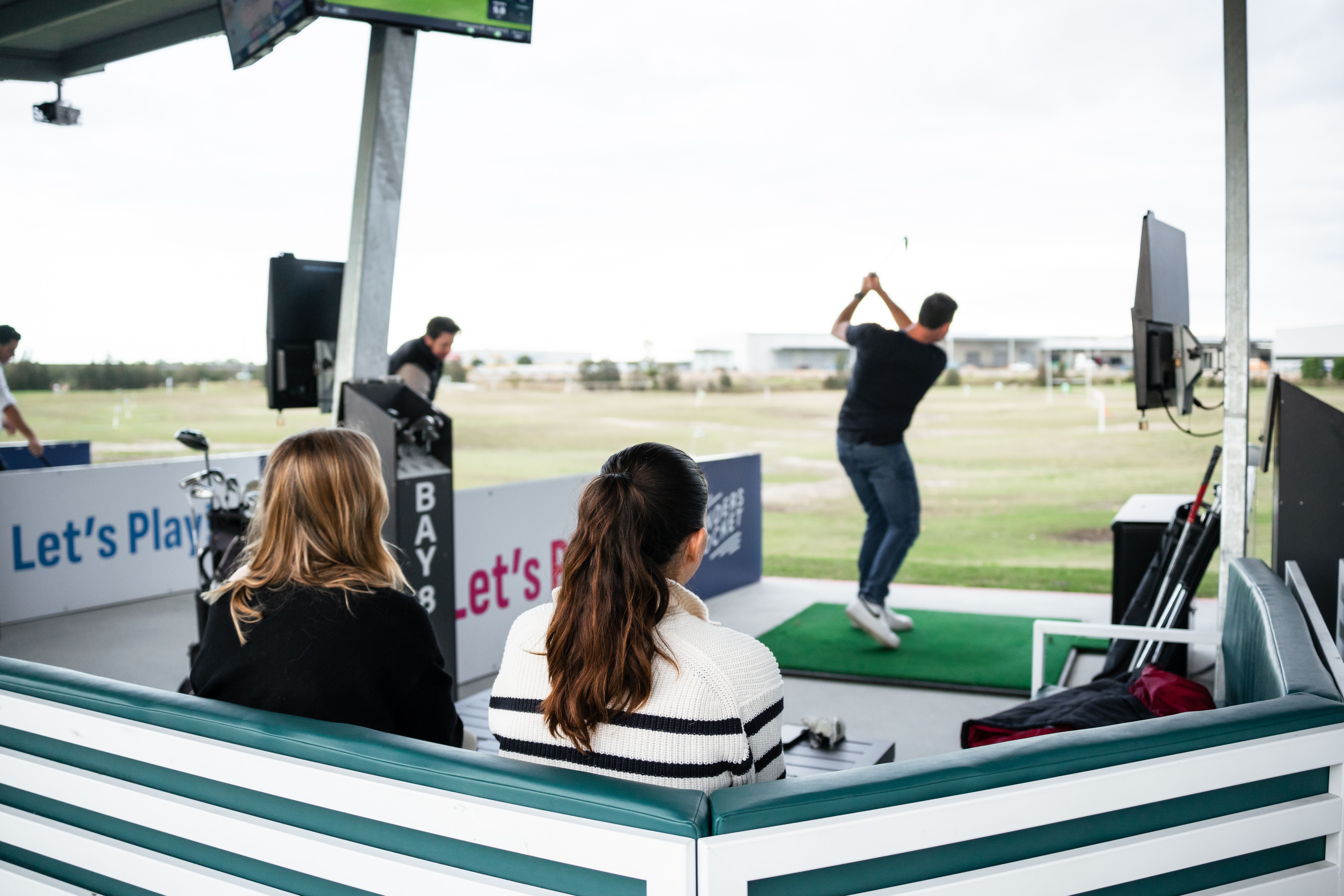 Man in red swinging golf club