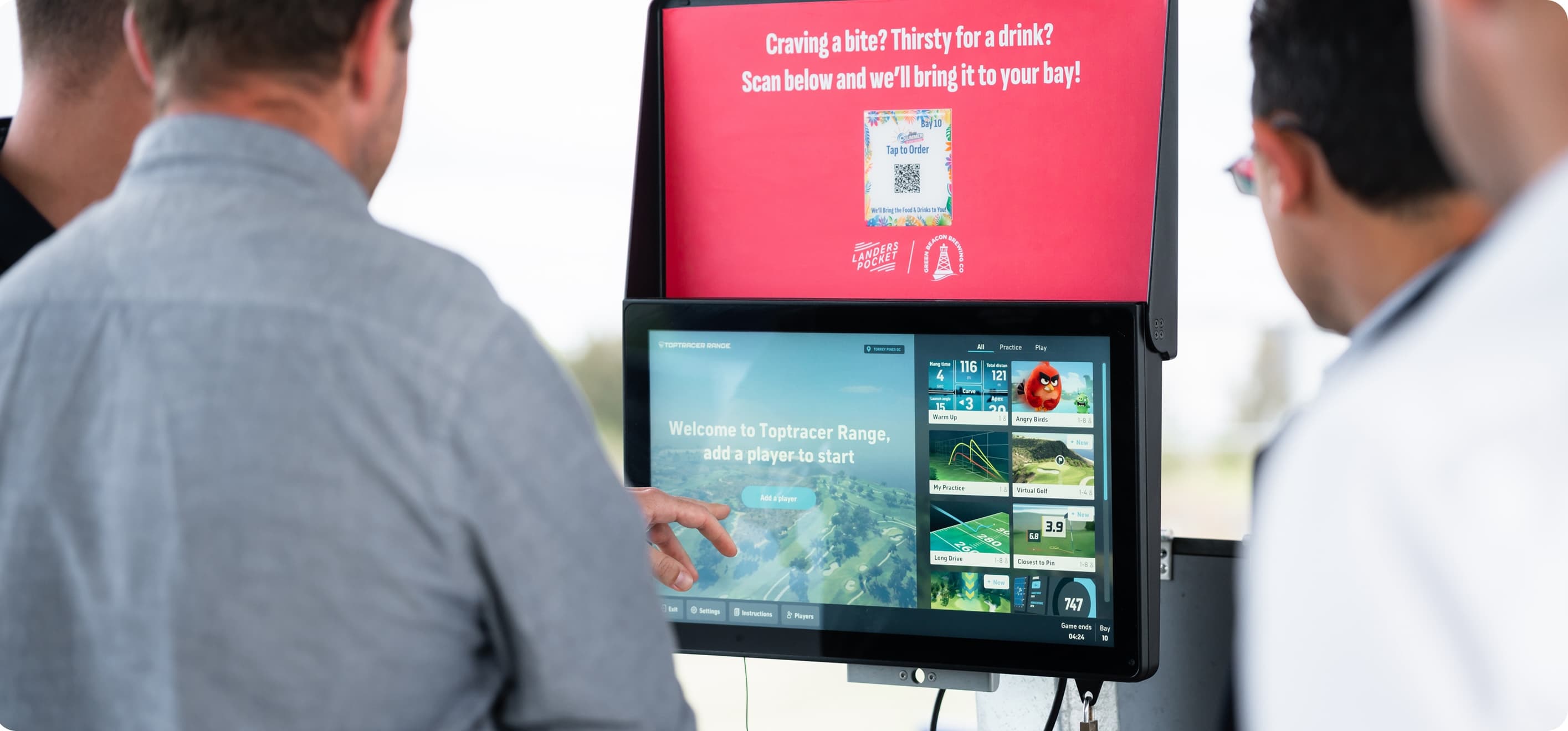 Men looking at performance scores on monitors