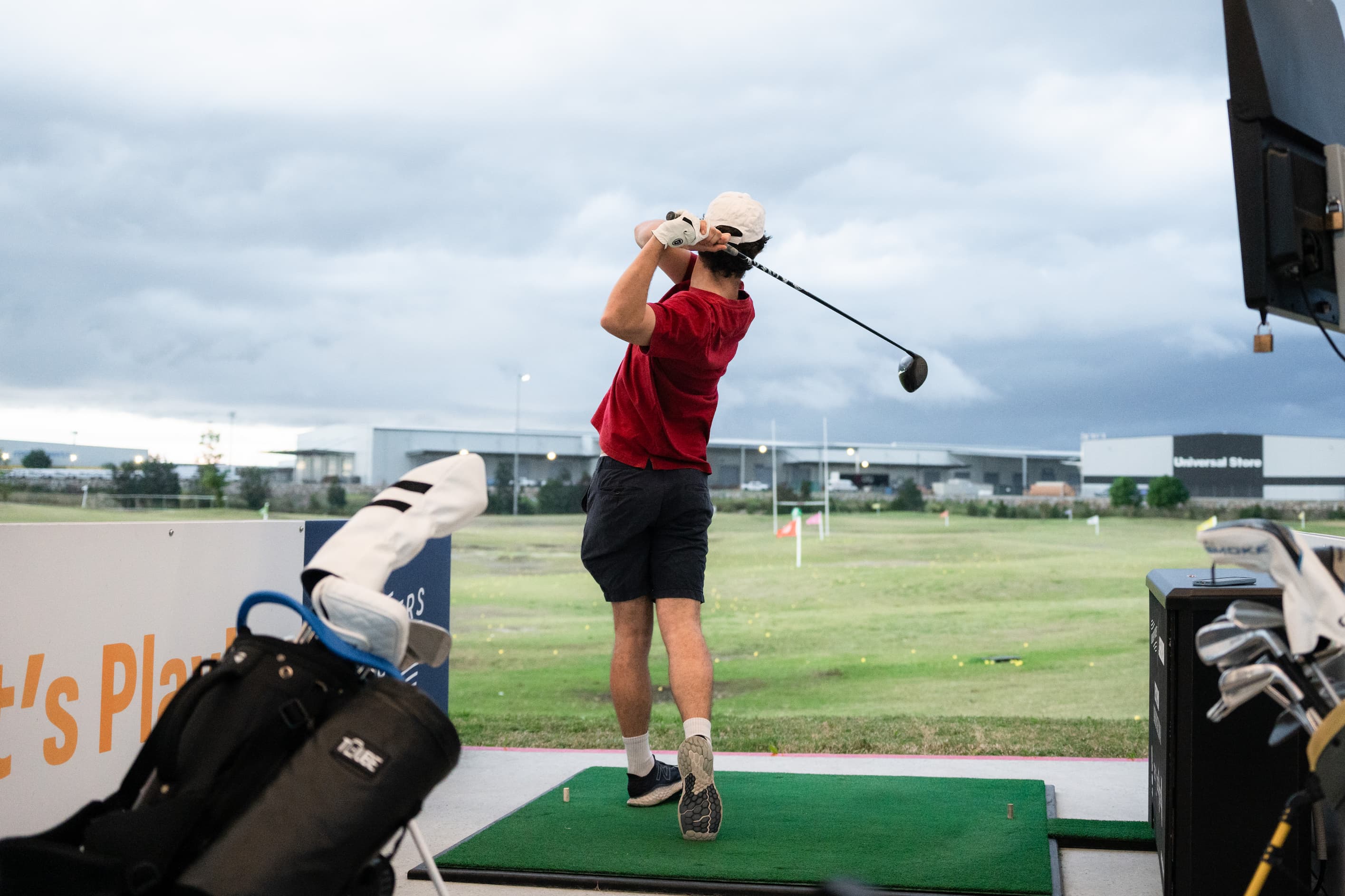 Man in red swinging a golf club