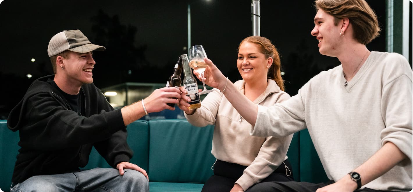 Three people doing a toast with drinks