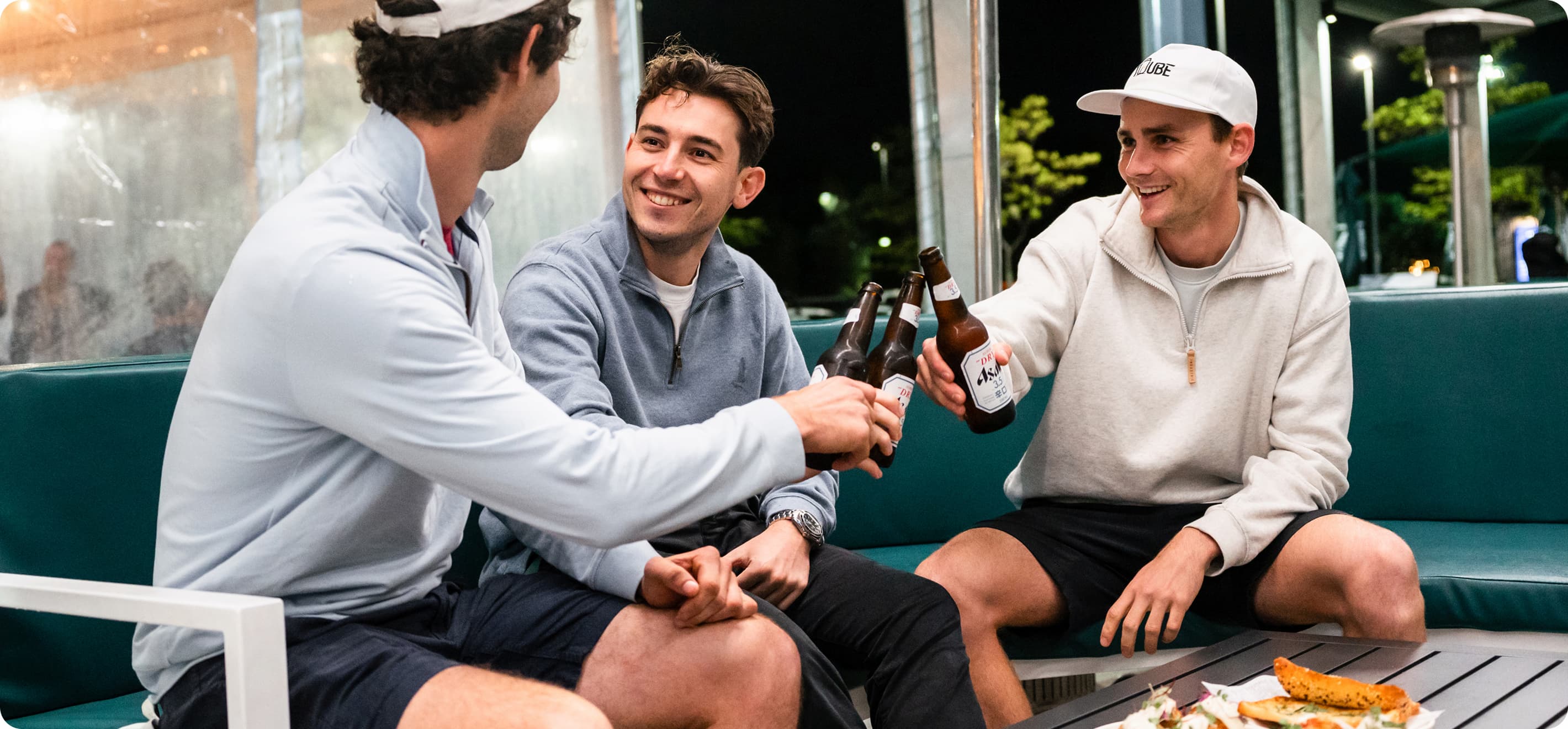 Three men toasting beers.