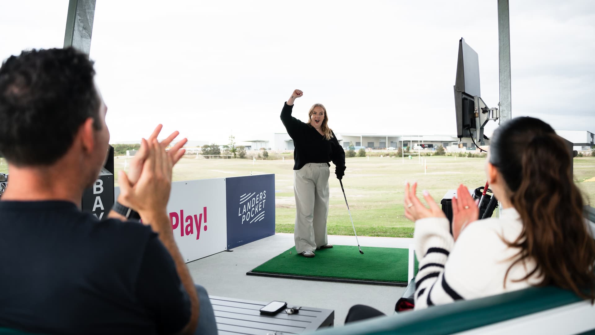 People cheering someone playing golf