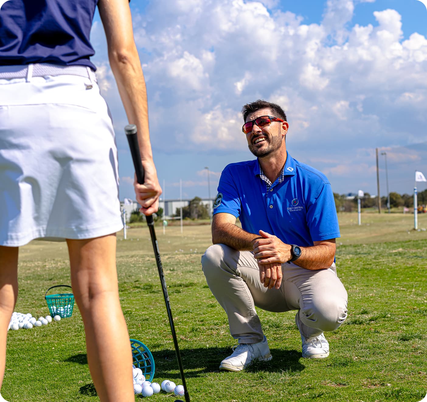 PGA coached lesson, man in blue kneeling