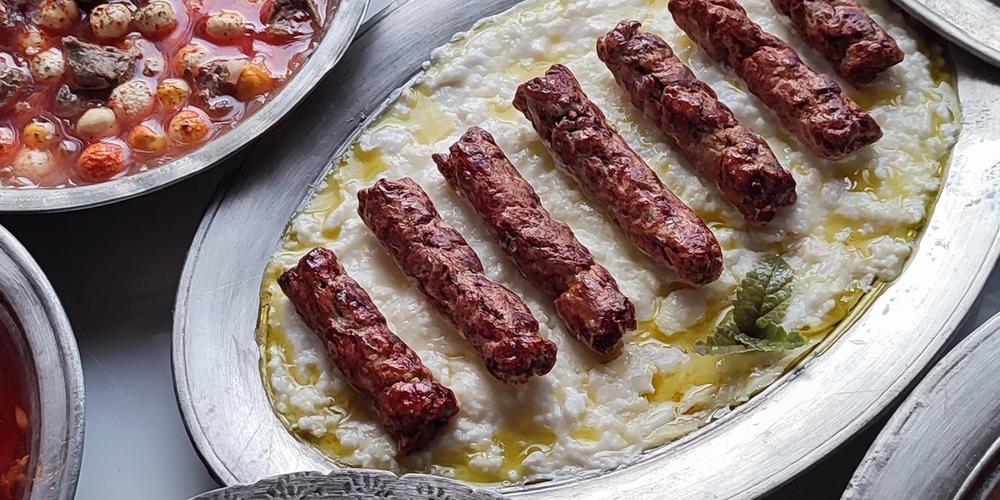 Gül İpek’in atölyesinde Gaziantep müzesi için hazırladığı yöresel yemek replikaları; ön planda Şiveydiz tabağı, çevresinde farklı yemek sunumları görülüyor.