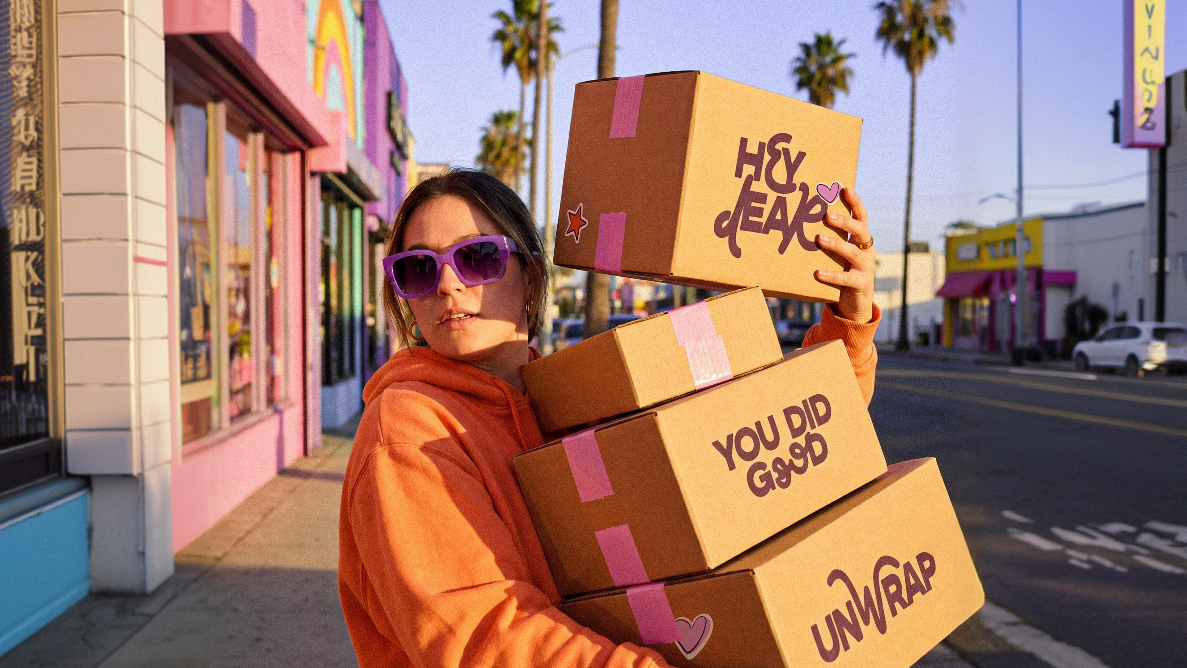 woman holding hey dear boxes at sunset