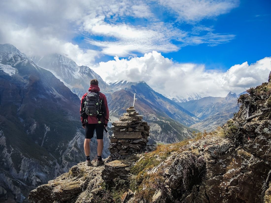A trekker on a ridge above a Himalayan valley