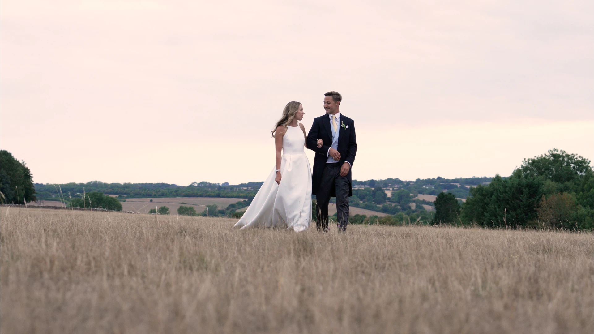 Archy & Katy, a married couple stand in a field
