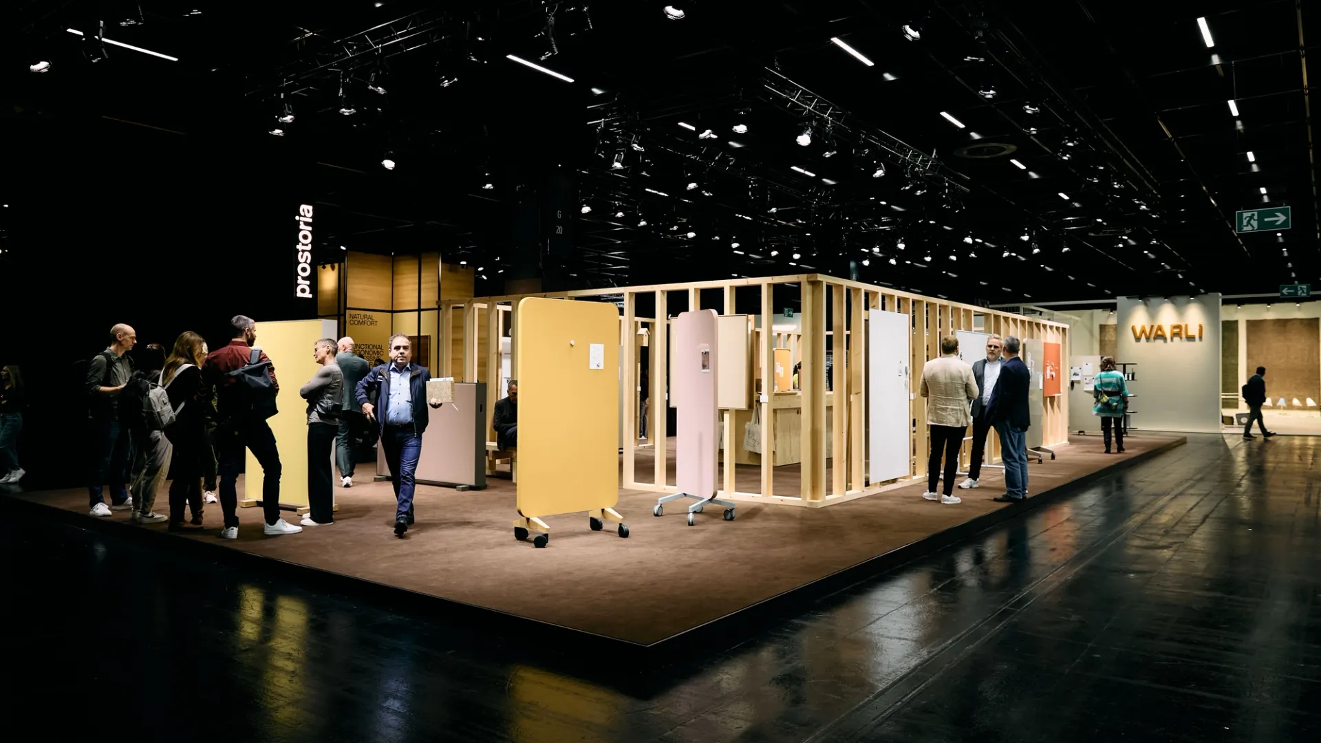 Des visiteurs près de tableaux mobiles colorés sur un stand de salon.