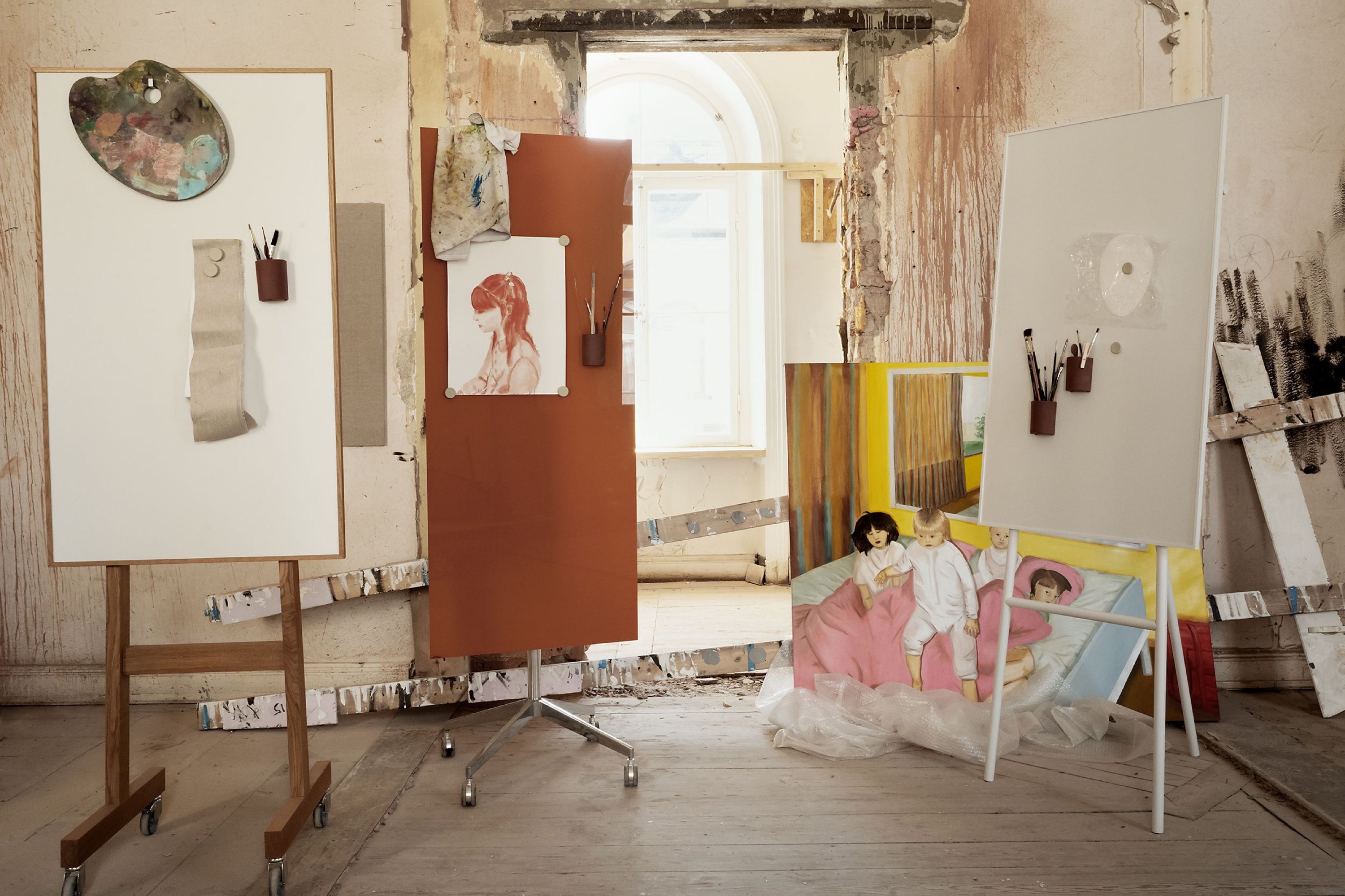 Writing boards and pinned sketches in the studio, with a painting on the floor