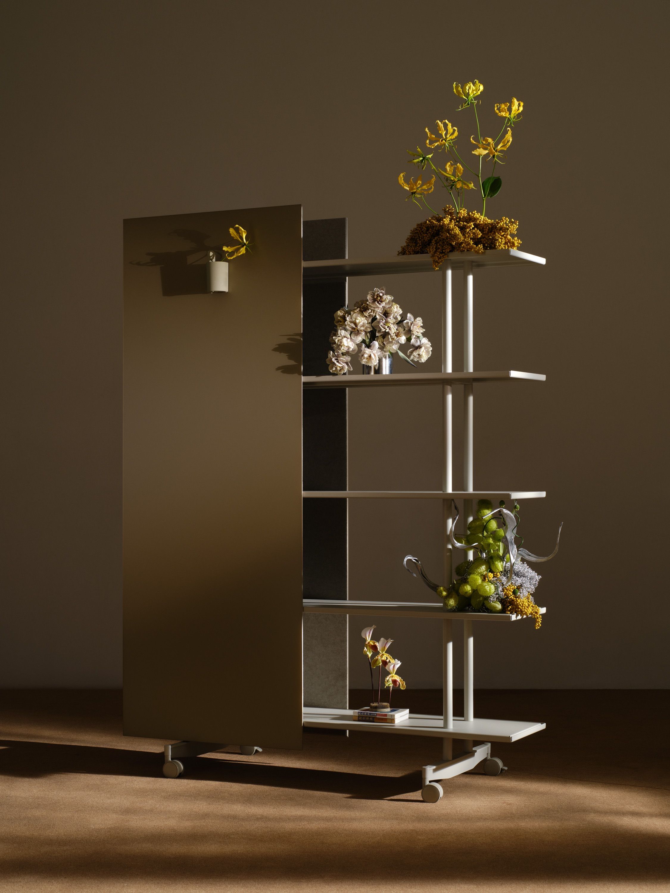 An A08 with a mirrored writing surface and flower arrangements on the shelves