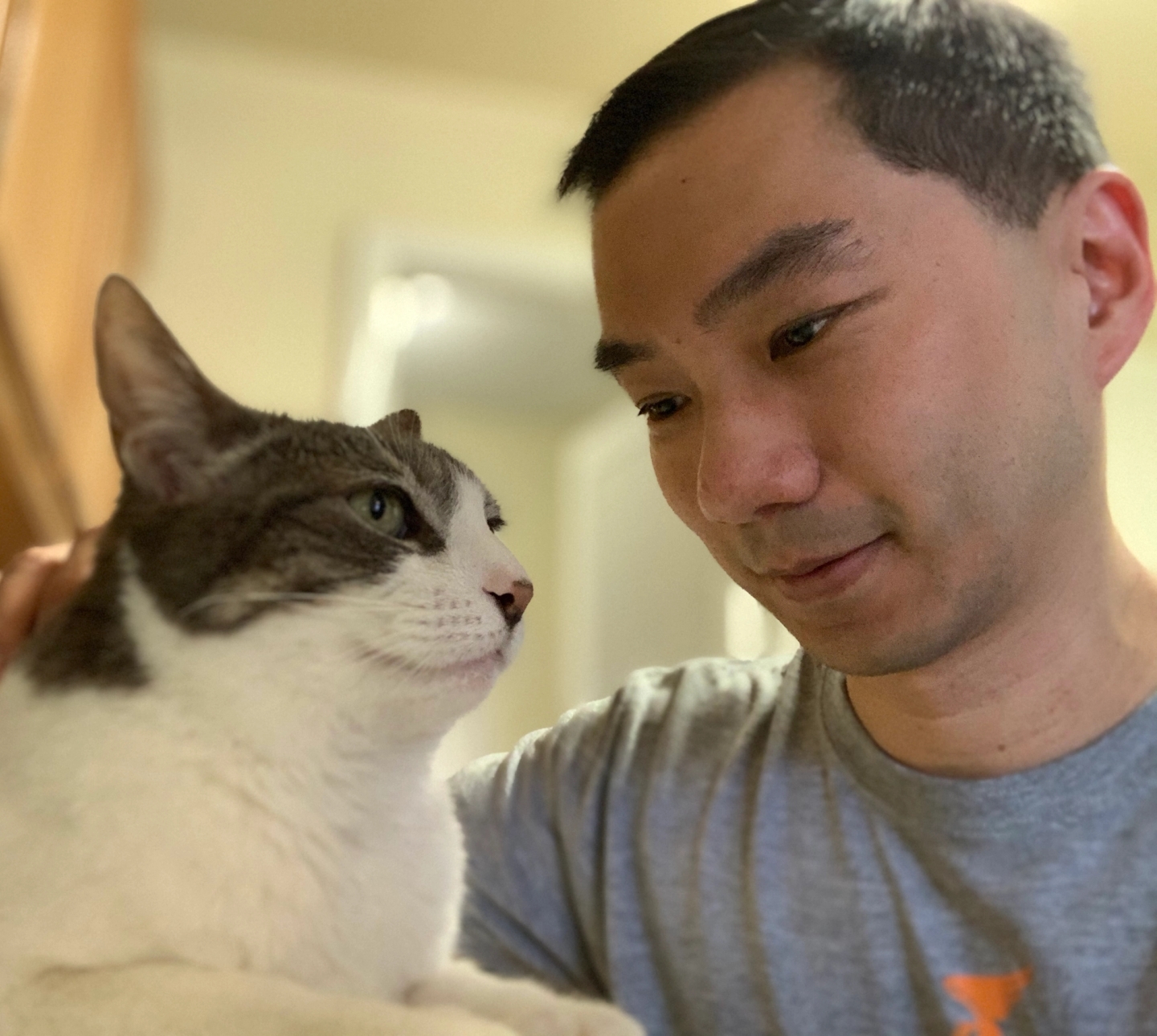 Cat Person co-founder Jimmy smiling at his cat Pebbles as she looks into the distance