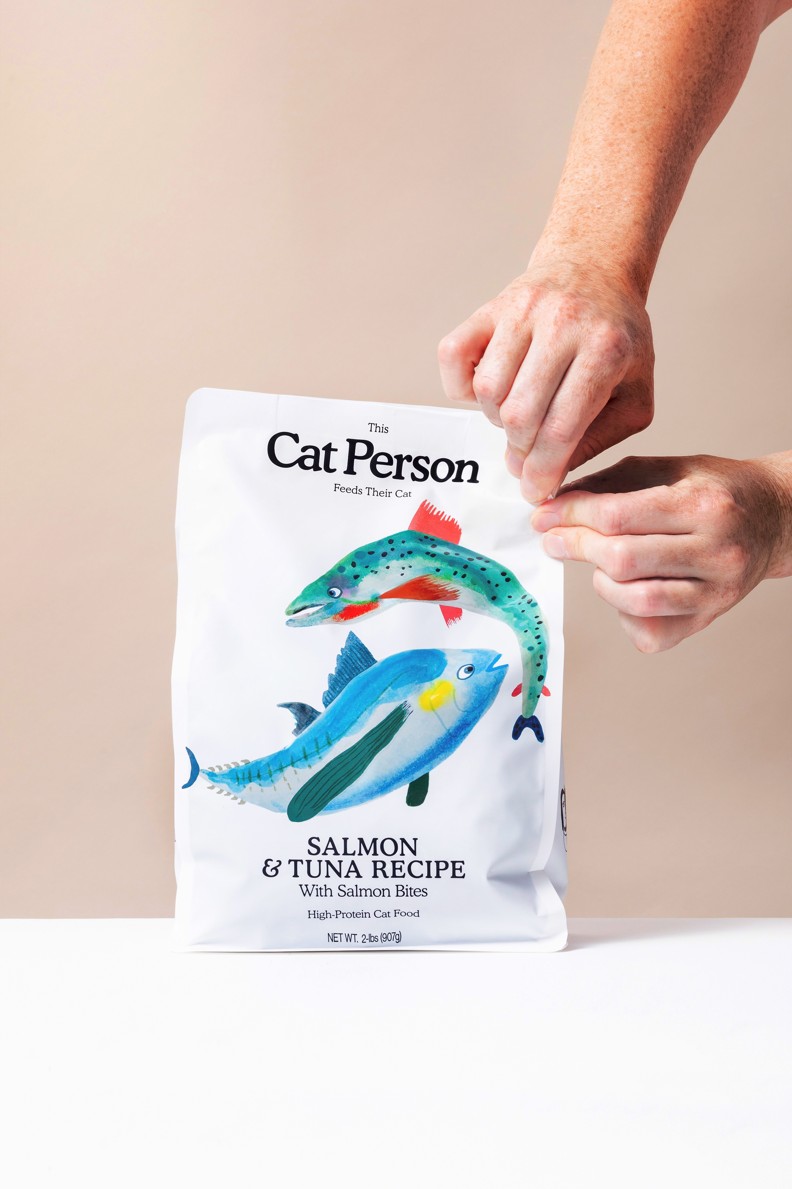 Cat person salmon & tuna dry food bag getting sealed by a person's hands