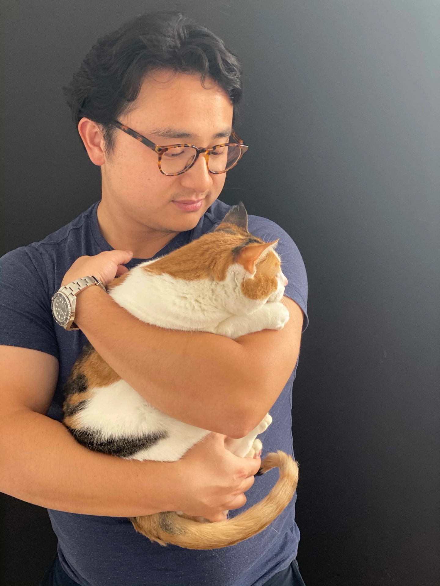 Cat Person co-founder Lambert gently gazes at a foster cat that he is holding in his arms