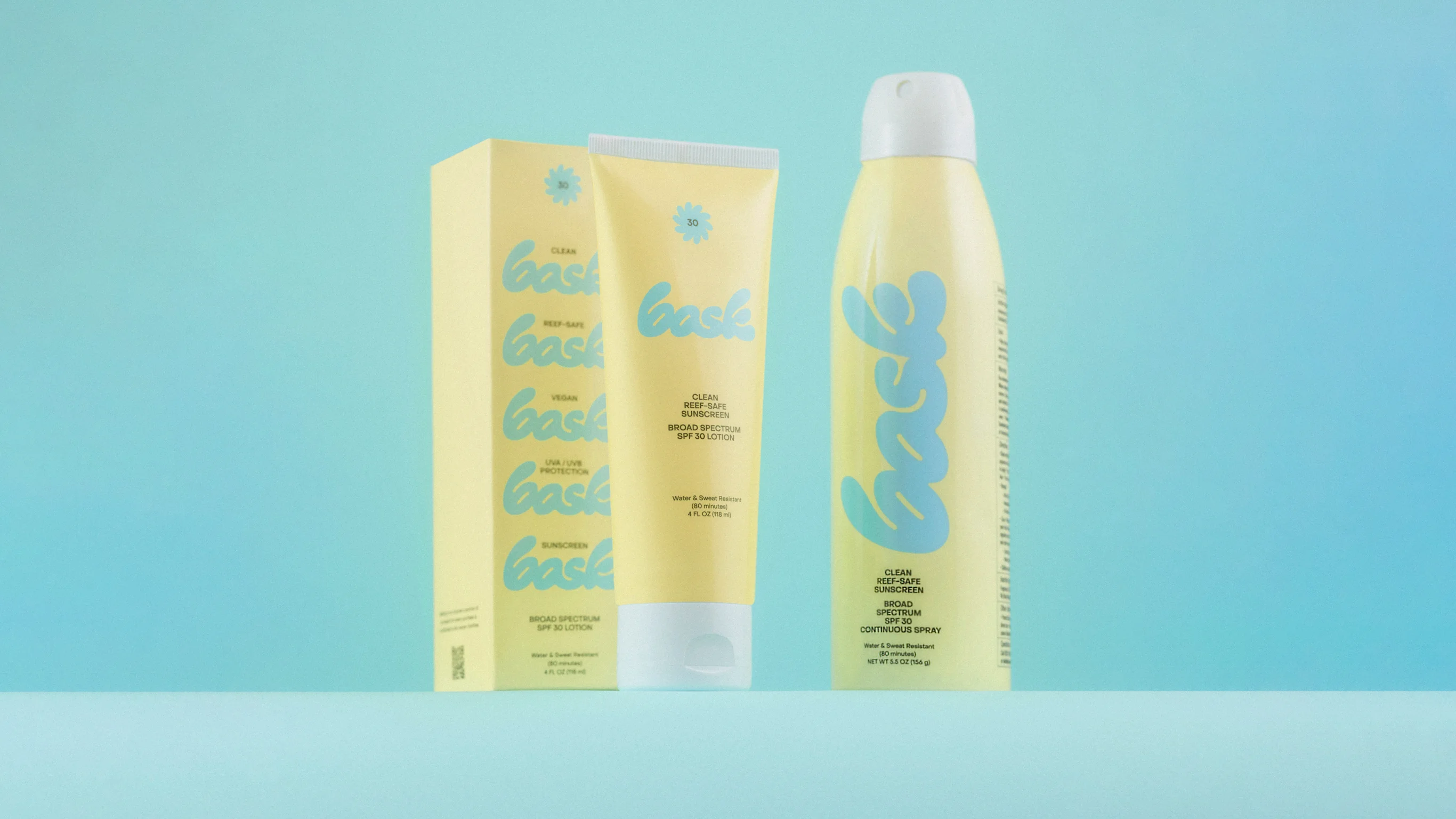 Bask Sunscreen Yellow Spray Bottle and Lotion Tube on Blue Background by RoAndCo