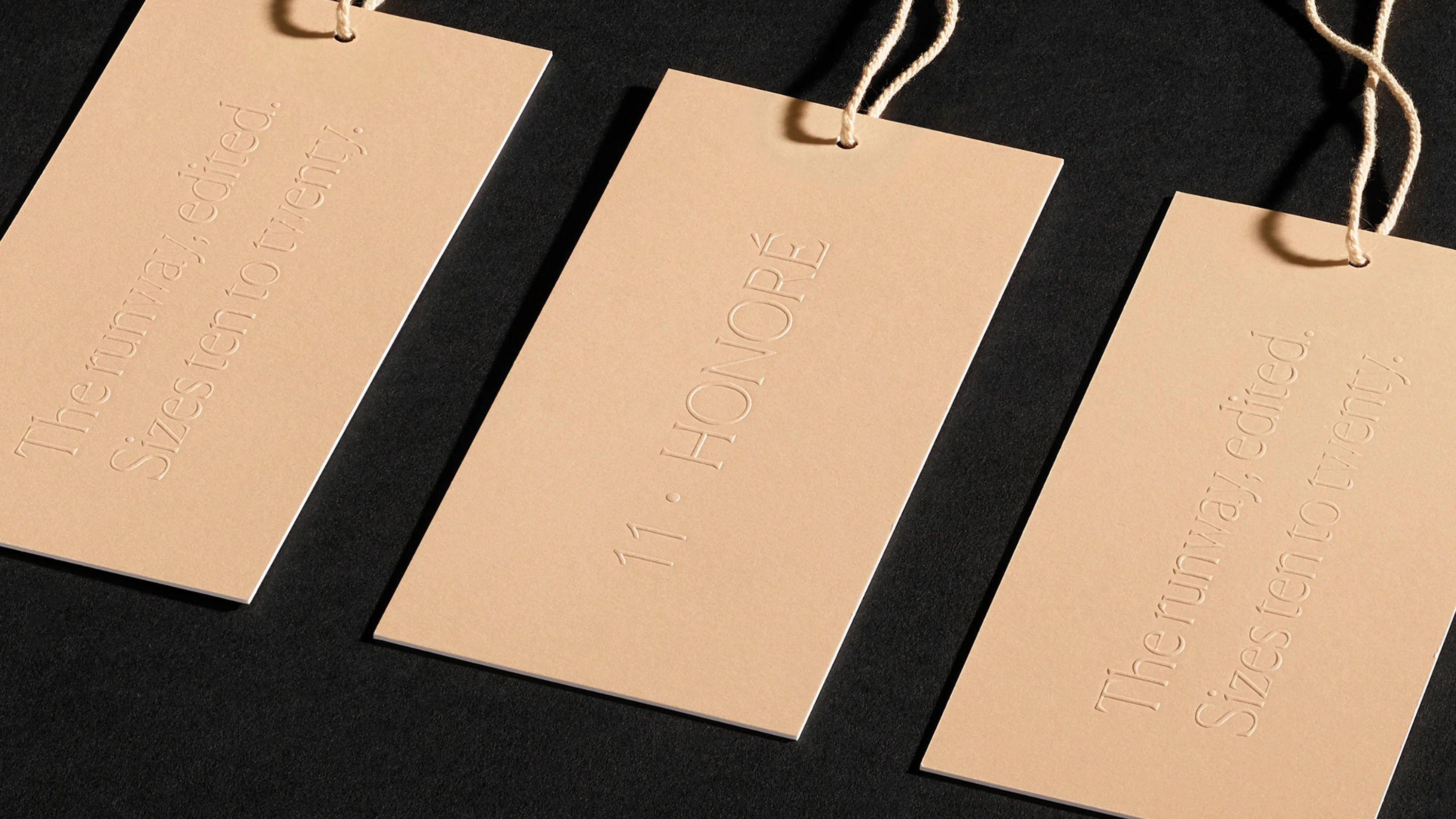Close up of embossed 11 Honoré hang tags, print design and branding by RoAndCo