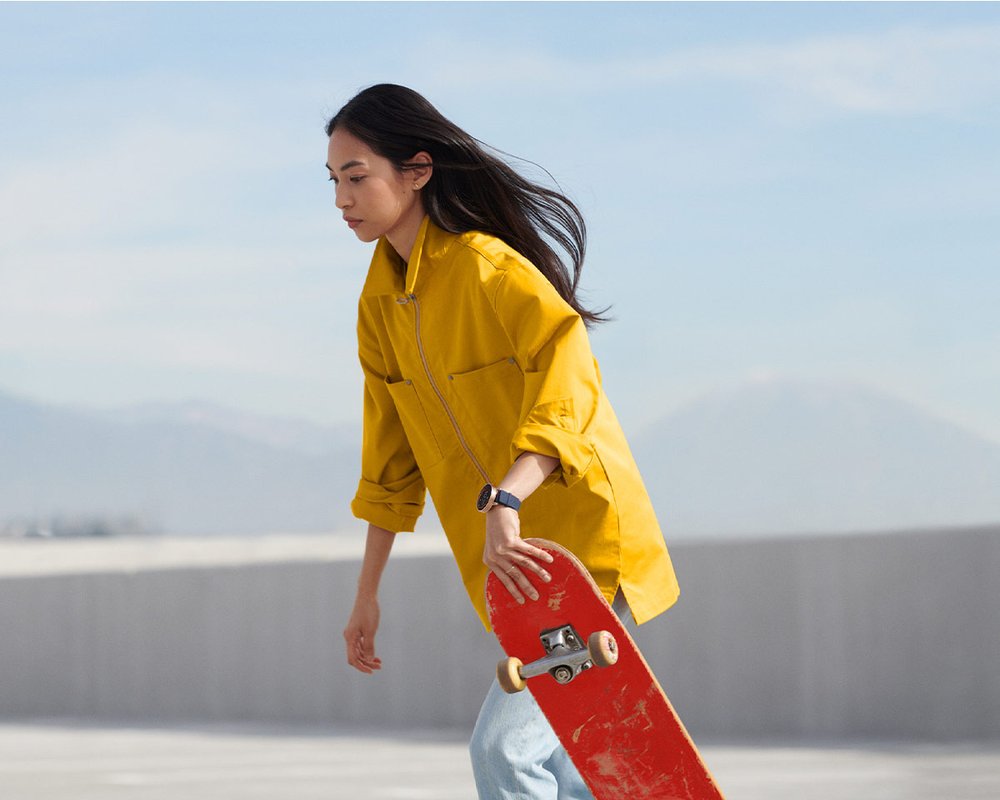 Woman skateboarding wearing a Google Wear OS watch