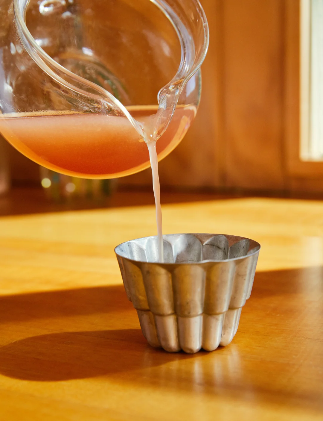 Making Gelee, pouring liquid gelatin mixture into a silver bundt mould