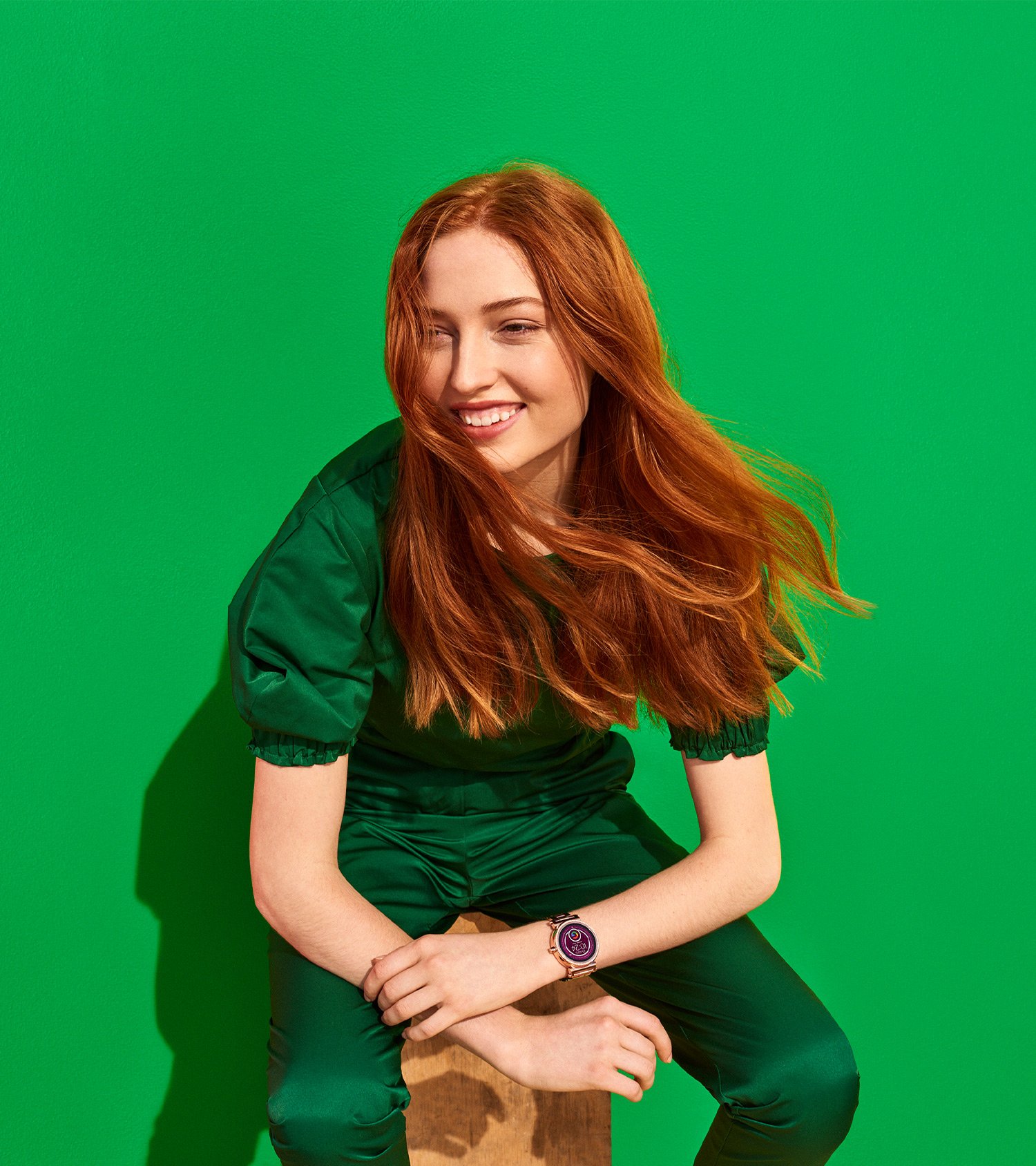 Woman in all green in front of green background wearing Google Wear OS watch, campaign Art Direction Design by RoAndCo