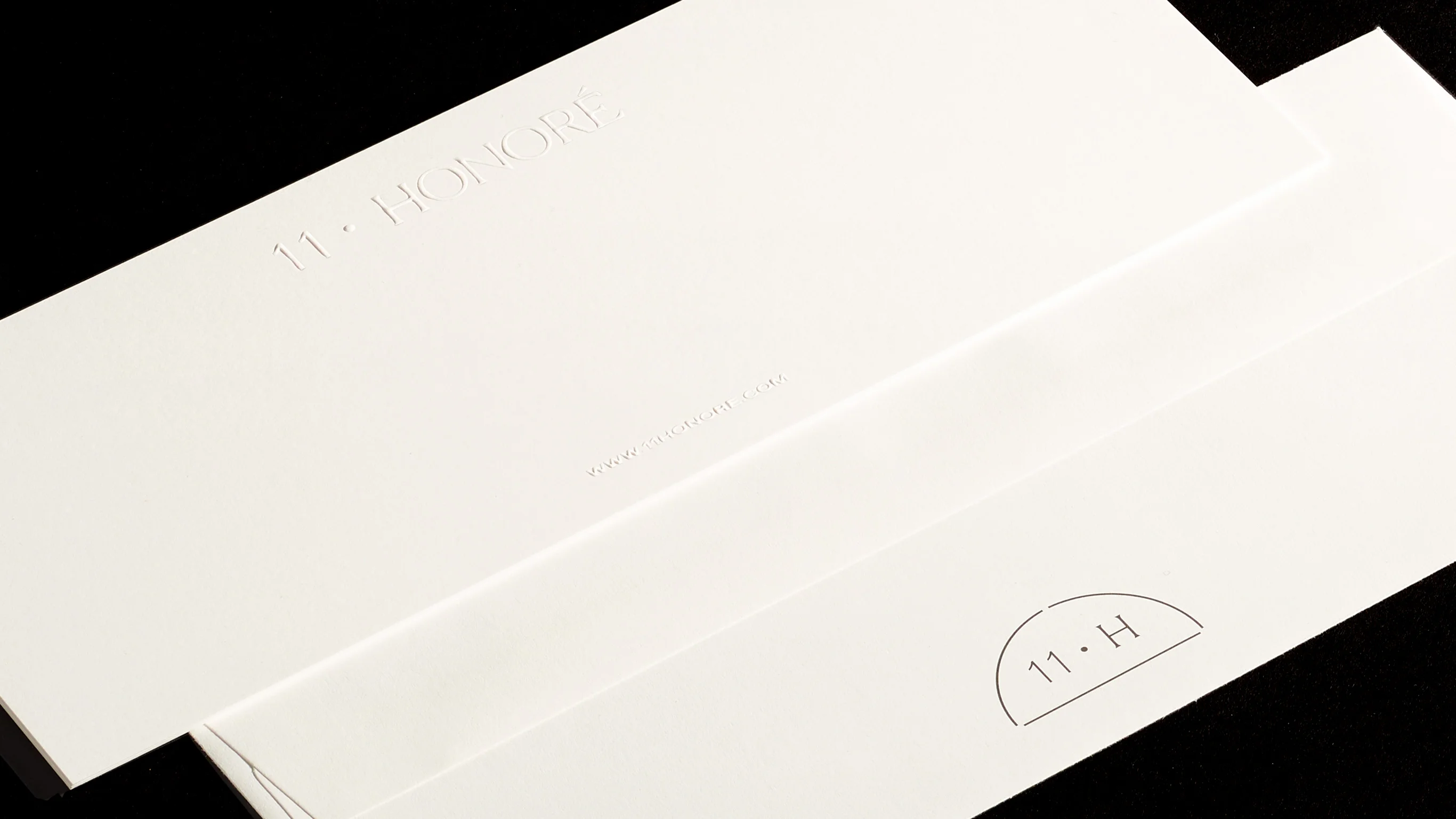 Close up of 11 Honoré embossed envelopes with 11 H seal, print design and branding by RoAndCo