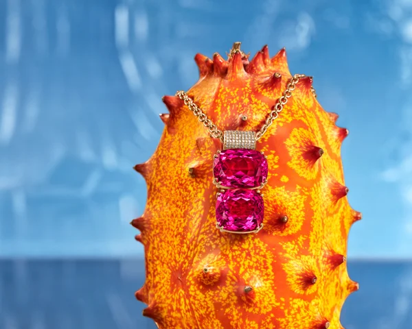 Irene Neurwirth jewelry in pink, purple, and gold atop florals creating a candy-colored garden scene. Art Direction by RoAndCo