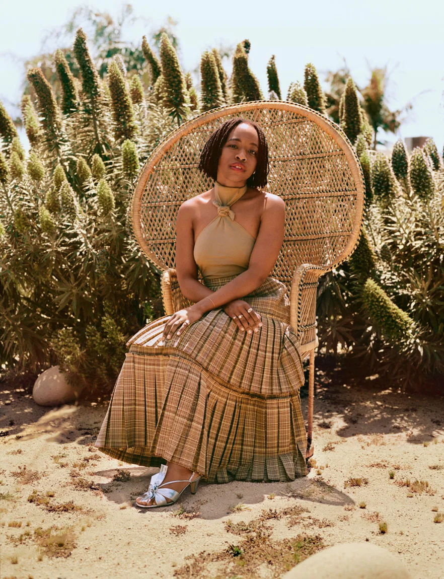 Erica Chidi Cohen, CEO and founder of Loom, seated in a garden wearing tan Gucci dress for Romance Journal Issue 03. Publication design, art direction, print design by RoAndCo. RoAndCo partnership with Gucci