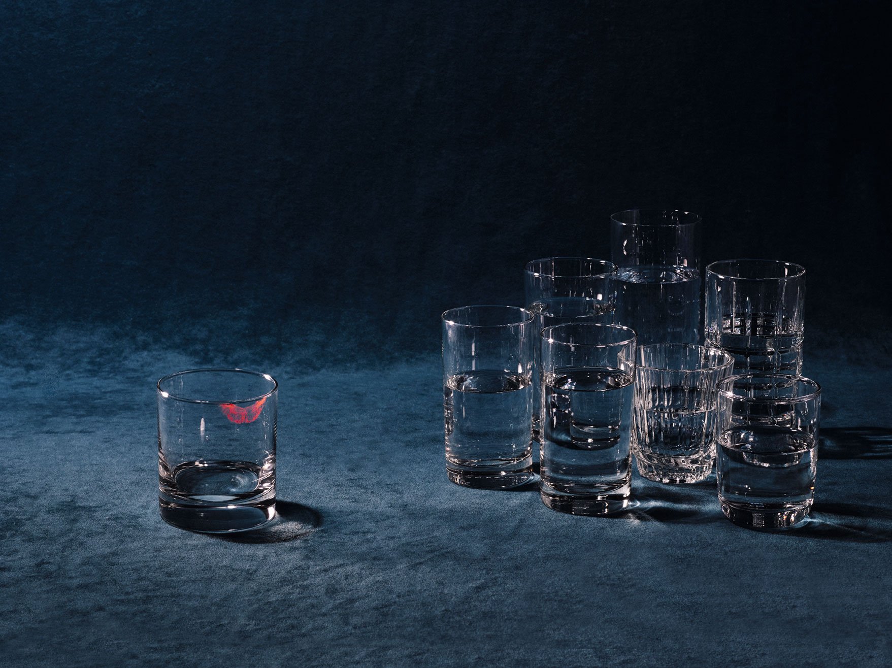 Still life image of various clear cups with one removed from the group and stained with a lipstick kiss for Romance Journal Issue 02 Resistance. Publication design, art direction, print design by RoAndCo.