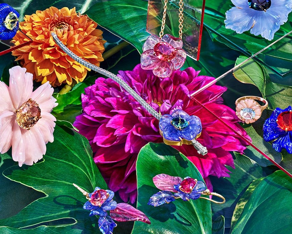 Irene Neurwirth jewelry in pink, purple, and gold atop florals creating a candy-colored garden scene. Art Direction by RoAndCo