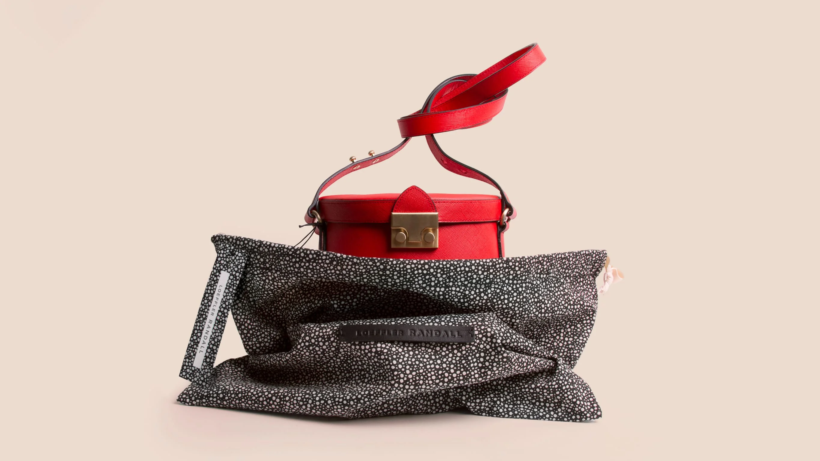 Red Loeffler Randall bucket bag nestled into custom print dust bag. Branding, packaging design and art direction by RoAndCo
