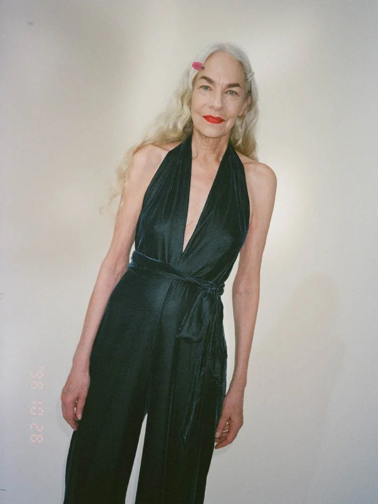 Behind the scenes campaign photo, female model in black jumpsuit. Campaign Art direction by RoAndCo