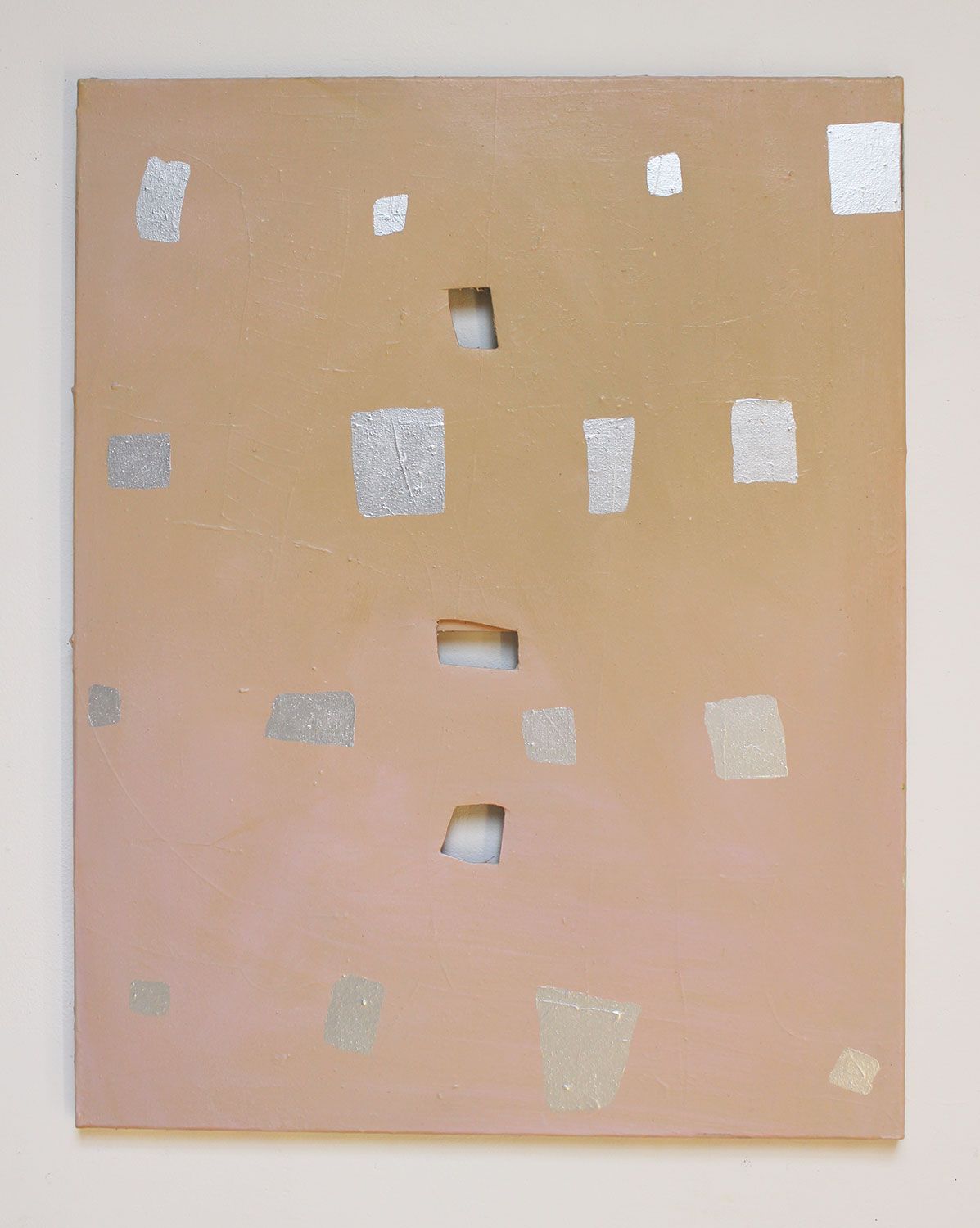 A beige board with irregular silver rectangles and three rectangular cut-outs.