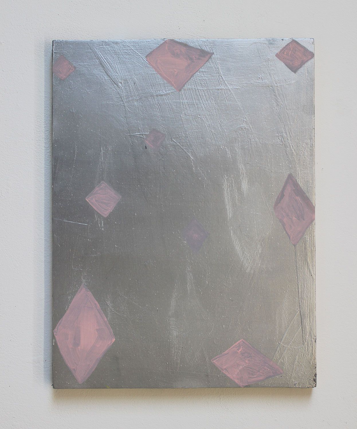 A canvas painting with a metallic silver background and pink diamond-shaped abstract patterns.